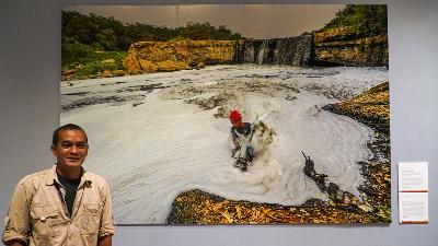 Fotografer Arie Basukibersama karyanya yang berjudul 'Polusi di Sungai Cileungsi' dalam pameran foto pemenang World Press Photo 2024, di Erasmus Huis, Jakarta, 24 Agustus 2024. Tempo/Martin Yogi Pardamean