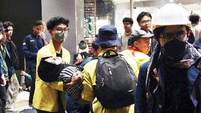 A student is taken to an ambulance after the police fired tear gas on Jalan Pemuda, Semarang, Central Java, August 26.
TEMPO/Budi Purwanto
