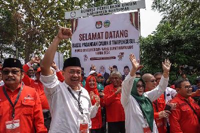 Bakal calon Bupati Banyumas Sadewo Tri Lastiono (kiri) dan bakal calon wakil bupati Banyumas Lintarti yang didukung 12 partai melambaikan tangan saat mendaftar di KPU Banyumas, Jawa Tengah, 29 Agustus 2024. ANTARA/Idhad Zakaria