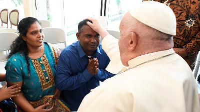 Pope Francis meets with Sri Lankan migrants, James Suthaharan and wife during his Apostolic visit to Asia, in Jakarta, September 3.
Vatican Media/Handout via REUTERS
