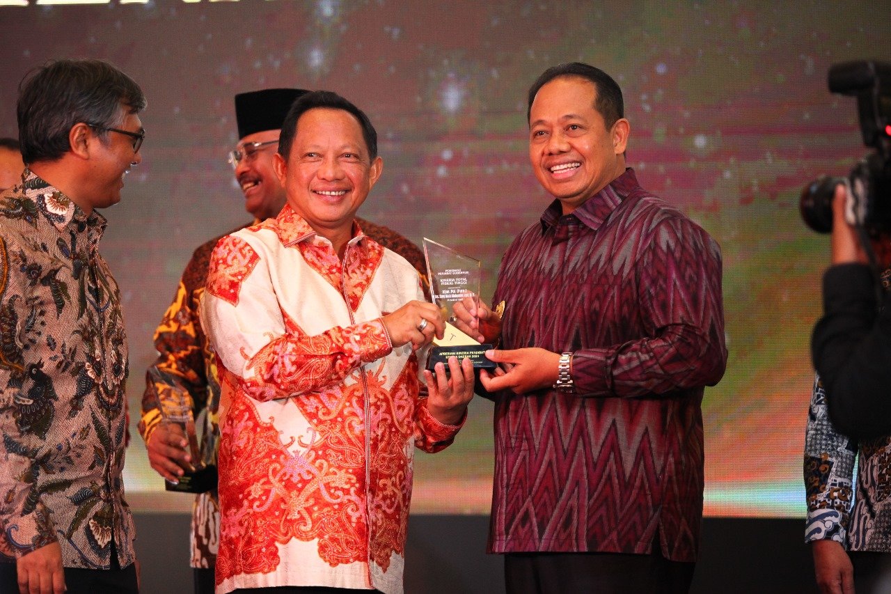 Penjabat Gubernur Bali, S. M. Mahendra Jaya (kanan), menerima penghargaan Apresiasi Kinerja Penjabat Kepala Daerah 2024 dari Menteri Dalam Negeri, Tito Karnavian di Hotel The Tibrata Darmawangsa, Jakarta, Jumat, 30 Agustus 2024. Dok. Tempo