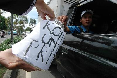 Seorang pengendara mobil memberikan uang pada kegiatan penggalangan dana Koin Untuk Prita Mulyasari di kawasan Cikokol, Tangerang, Banten, 2009. Dok. TEMPO/ Tri Handiyatno