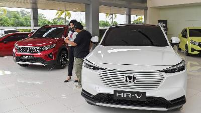 A salesperson provides product information and new car prices at a Honda Dealership in Depok, West Java, on Tuesday, January 7, 2025. Minister of Industry Agus Gumiwang Kartasasmita said the additional vehicle "opsen" or tax surcharge tax policy would burden the automotive industry. TEMPO/M Taufan Rengganis