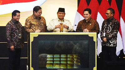 President Prabowo Subianto, accompanied by Coordinating Minister for Economic Affairs Airlangga Hartarto (second left), Minister of State-owned Enterprises Erick Thohir (second right), President Director of Pegadaian Damar Latri Setiawan (right), and President Director of Bank Syariah Indonesia Hery Gunardi (left) insert gold bars into a box during the inauguration of the Gold Bank Service of Pegadaian and Bank Syariah Indonesia at The Gade Tower, Jakarta, February 26, 2025. Tempo/Imam Sukamto