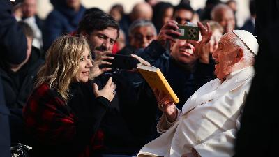 Paus Fransiskus saat memberi hadiah ulang tahun kepada wartawan Tempo Francisca Christy Rosana di dalam pesawat menuju Singapura, 11 September 2024. Dok. Francisca Christy Rosana