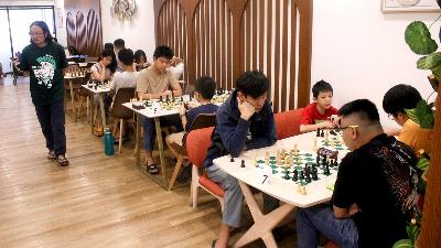 Seorang anak yang merupakan bagian dari Komunitas Chessnuts bermain catur di kafe Spring Delight, Muara Karang Jakarta Utara, 1 Juni 2025. Tempo/Magang/Muhammad Rizky Fadhlurahman.