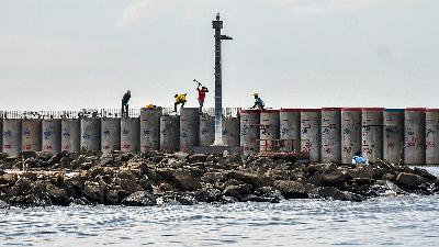 Sejumlah pekerja mengerjakan proyek pembangunan tanggul laut atau National Capital Integrated Coastal Development (NCICD) Fase A dengan panjang total 21 kilometer di kawasan Ancol Barat, Jakarta Utara, 12 Mei 2025. Pembangunan NCICD Fase A yang menjadi kewenangan Pemprov Jakarta itu diproyeksikan rampung pada 2030. Antara/Sulthony Hasanuddin