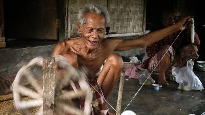Seorang petani memintal kapas hasil kebun Bidadariku. Instagram/bidadarikuofficial