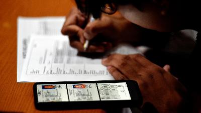 An employee of the Population and Civil Registry Office records residents' personal data while processing population administration, in Makasar Urban Village, East Jakarta, July 24, 2025. Tempo/Imam Sukamto