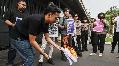 Executive Director of Lokataru Foundation Delpedro Marhaen burns the Draft RKUHAP during a protest against the legislative process of discussing the Draft Criminal Procedure Code (RKUHAP) at the Pancasila Gate of the DPR, Jakarta, July 11, 2025. Doc. Tempo/M Taufan Rengganis
