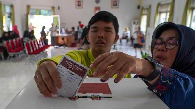 A visually impaired voter, assisted by a companion, exercises their voting rights at Polling Station (TPS) 007, Cawang Subdistrict, Kramatjati District, East Jakarta, Wednesday, November 27, 2024. A total of 65 persons with disabilities listed in the Permanent Voter List (DPT) cast their ballots at this polling station. The voting process was designed to be disability-friendly, ensuring that every voter could cast their vote comfortably and independently. Tempo/Martin Yogi Pardamean