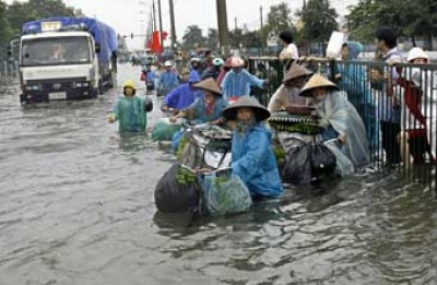 Pengendara sepeda di Hanoi Vietnam berusaha melewati jalan yang banjir  (3/11). Foto: AP/Chitose Suzuki