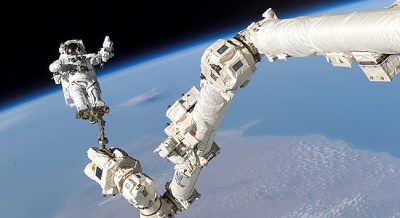 Astronaut Stephen K. Robinson, saat melaksanakan misi STS-114. Astronot diikat menggunakan lengan robotik, untuk mencegah astronot terlepas. Kegiatan ini disebut  extravehicular activity (EVA), astronot dapat bertahan hidup berkat baju yang digunakan, 13 Agustus 2005. NASA/Getty Images