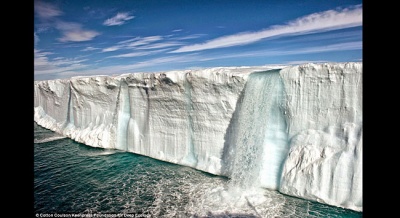 Es yang mencair menciptaka air terjun di North East Land, Svabard, Norwegia. Pemanasan global mebuat es di Artik dan Antartika mencair. dailymail.co.uk