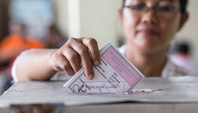 Seorang warga memasukkan surat suara ke dalam kotak dalam Pilkada ulang Walikota dan Wakil Walikota Denpasar di tempat pemungutan suara (TPS) 6, Desa Sesetan, Denpasar, Bali, 13  Desember 2015. Pemungutan suara ulang di TPS itu direkomendasikan oleh Panitia Pengawas Pemilu karena adanya 6 warga yang menggunakan formulir C6 atas nama orang lain pada Pilkada serentak, 9 Desember lalu. TEMPO/Johannes P. Christo