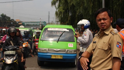 Walikota Bogor, Bima Arya mengatur arus lalu lintas untuk mengurai kemacetan yang terjadi di Kota Bogor, 6 Januari 2016. Politisi PAN tersebut mengatakan, banyak persoalan yang menjadi catatan terkait kemacetan di Bogor, antara lain parkir liar di trotoar, angkot yang kerap ngetem menghambat laju kendaraan, PKL, parkir ojek yang menggunakan badan jalan, serta aktivitas warga yang menyebrang sembarangan. Lazyra Amadea Hidayat