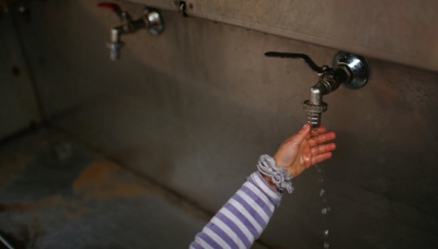 Seorang gadis Palestina menggunakan keran umum untuk mencuci tangannya di kamp pengungsi Jabaliya di utara Jalur Gaza, Palestina, 24 Januari 2017. REUTERS