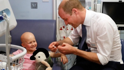 Pangeran William berbincang dengan bocah pengidap kanker saat berkunjung ke rumah sakit Royal Marsden di Sutton, Inggris, 16 Mei 2017. Pangeran William tampak menghibur sejumlah pasien anak pengidap kanker dalam kunjungannya tersebut. AP Photo/Kirsty Wigglesworth, Pool