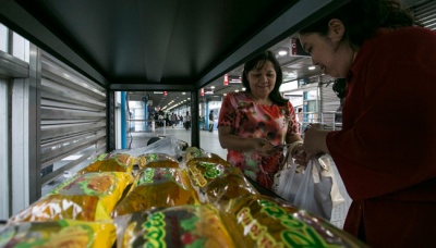 Seorang penumpang Transjakarta membeli bahan pangan yang dijual di stand Sembako on Shelter (SOS) di Halte Transjakarta Harmoni, Jakarta, 29 Mei 2017. TEMPO/Rizki Putra